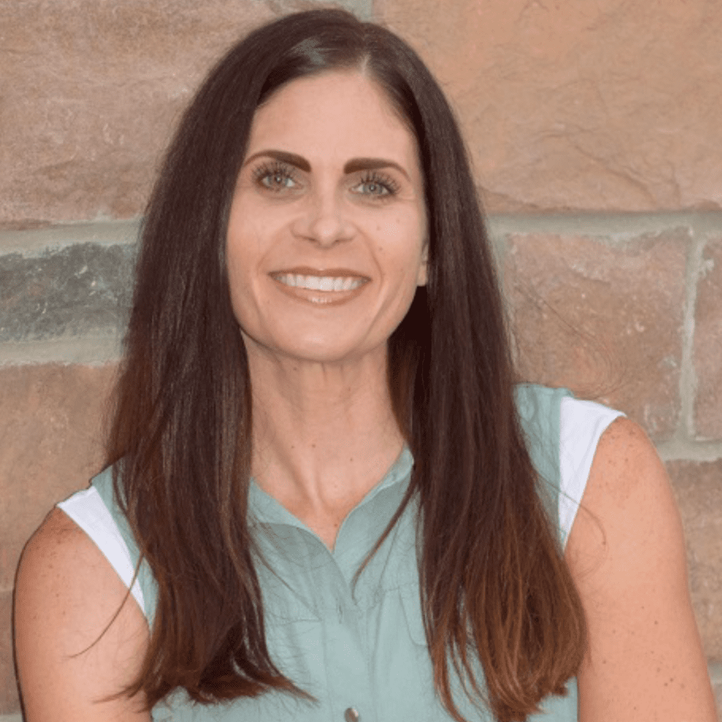 Mindy Dare posing with brick wall backgound